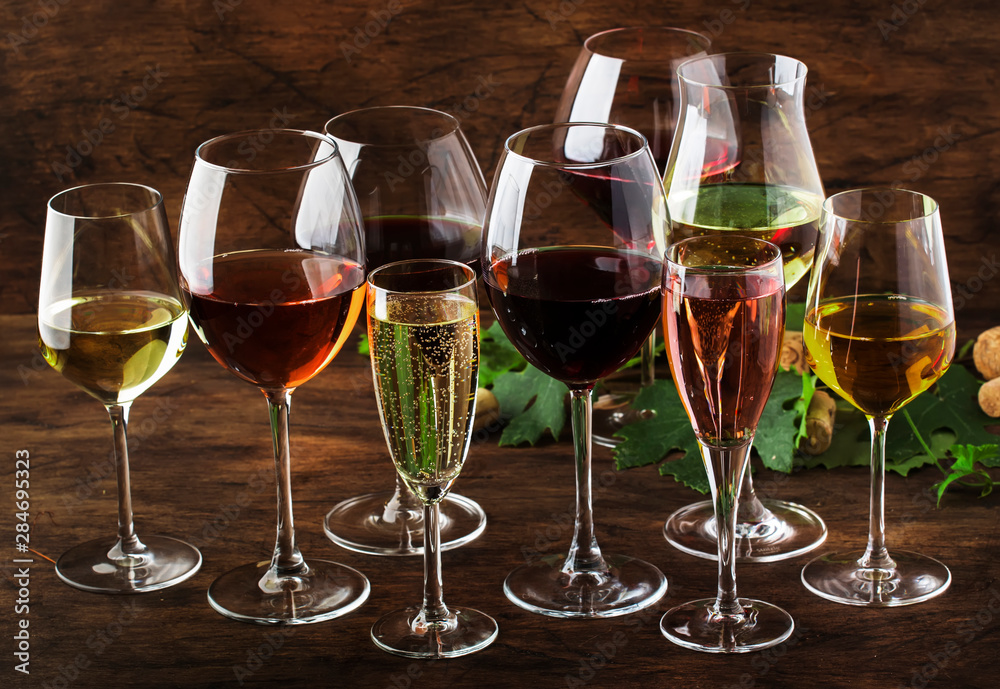 Wine tasting, still and sparkling wines. Red, white wine, rose and champagne шт assortment in wine glasses on vintage wooden table background Wine tasting, still and sparkling wines. Red, white wine, rose and champagne шт assortment in wine glasses on vintage wooden table background