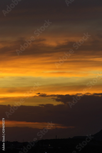 Fototapeta Naklejka Na Ścianę i Meble -  Abstract nature background. Dramatic sunset sky in the clouds saturated with bright colors of orange and yellow. Contrast Low Key