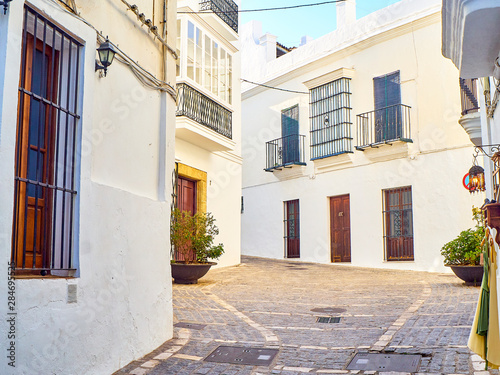 A typical street with whitewashed walls of Vejer de la Frontera downtown. View from the Jose Castrillon street. Cadiz province, Andalusia, Spain. photo