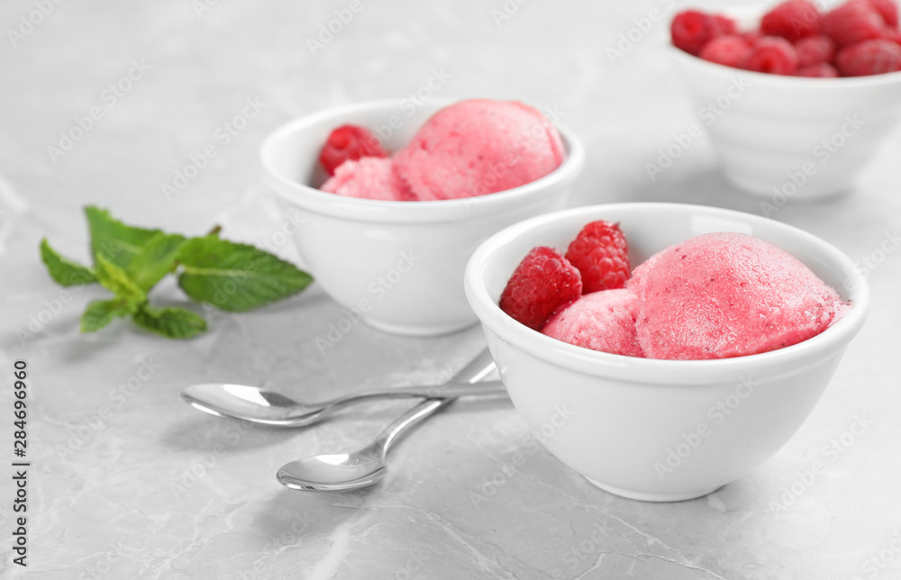 Bowls with delicious raspberry ice cream on grey marble table Bowls with delicious raspberry ice cream on grey marble table