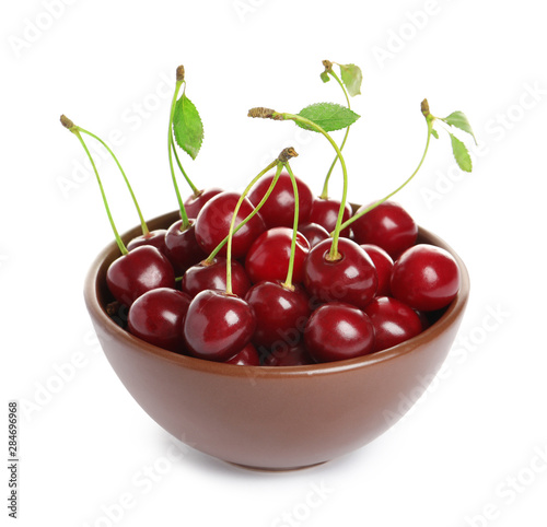 Ceramic bowl of delicious ripe sweet cherries on white background