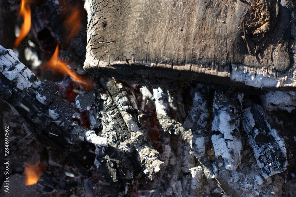 The flame burns the charcoal in the stove causing
