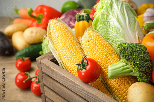 Fresh vegetables and wooden crate on table  closeup