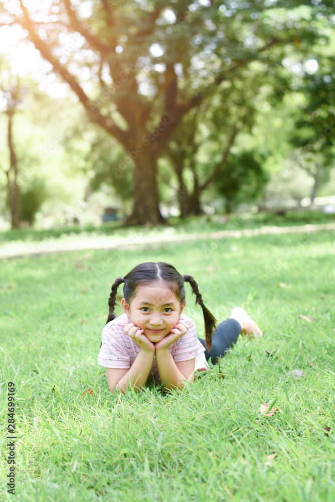 Little cute girl smiling & laying on the grass Little cute girl smiling & laying on the grass