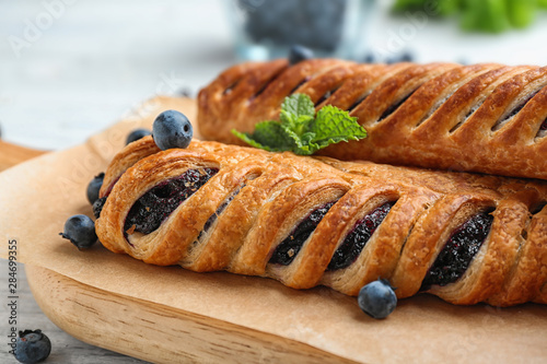 Fresh delicious puff pastry with sweet berries served on white wooden table, closeup