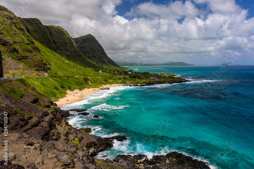 A view of Makapu u beach  on the east side of Oahu  Hawaii.  The day is sunny and the sky is blue