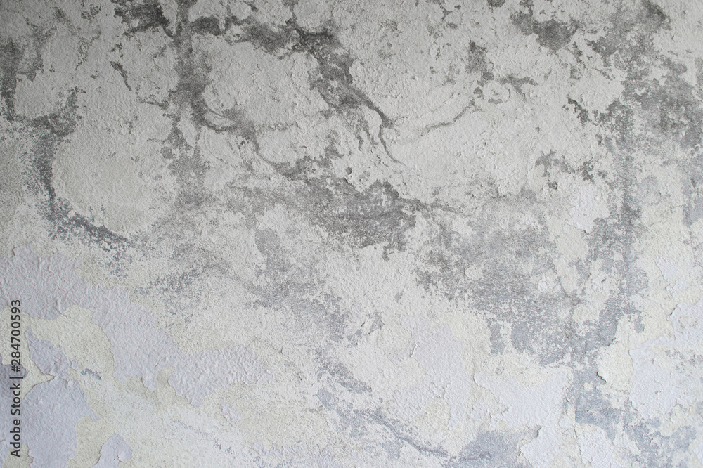 A gray concrete wall with a vertical lighting gradient interspersed with white plaster and paint. Background A gray concrete wall with a vertical lighting gradient interspersed with white plaster and paint. Background