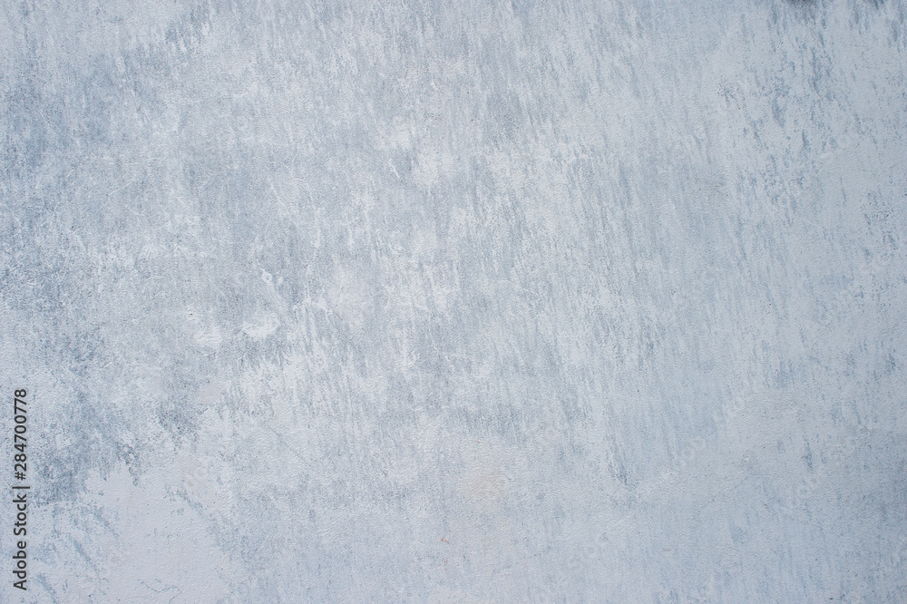 A gray concrete wall interspersed with white plaster. Background
