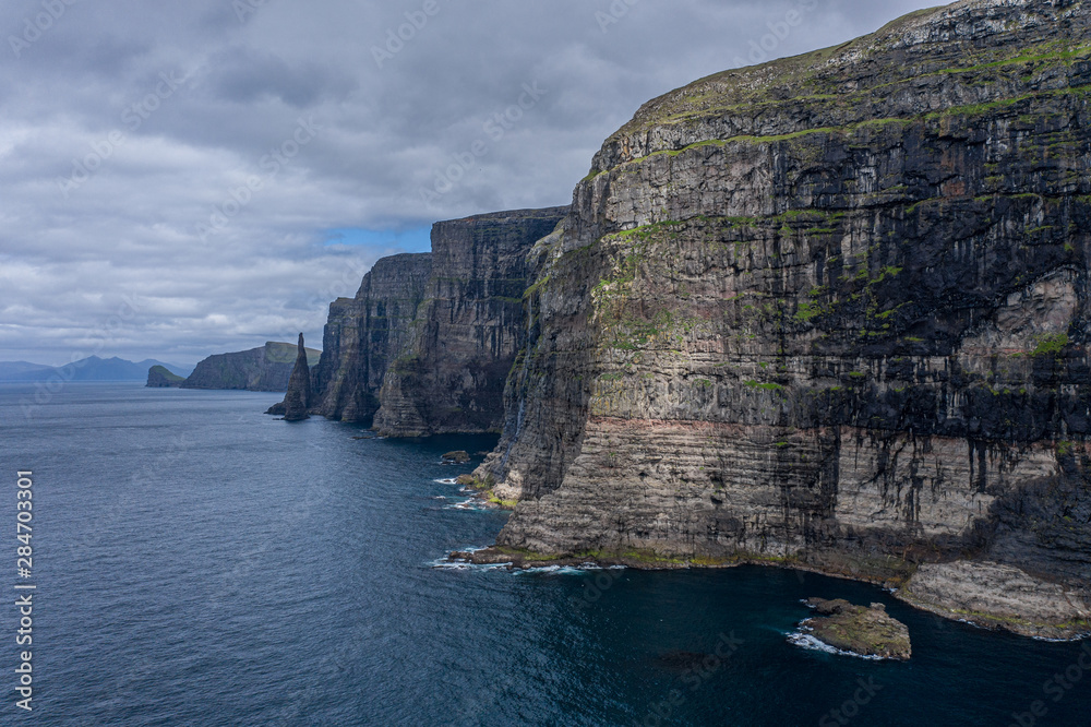 Panoramic aerial view from Sandoy island cliffs and rock stacks under the clouds, Faroe Islands