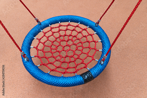 Rope circle blue on a swing. Red rope web close up. Children's entertainment.