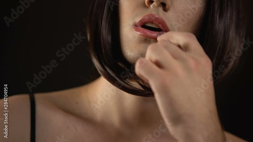 Brunette male transgender applying lipstick, gay makeup quality cosmetics photo