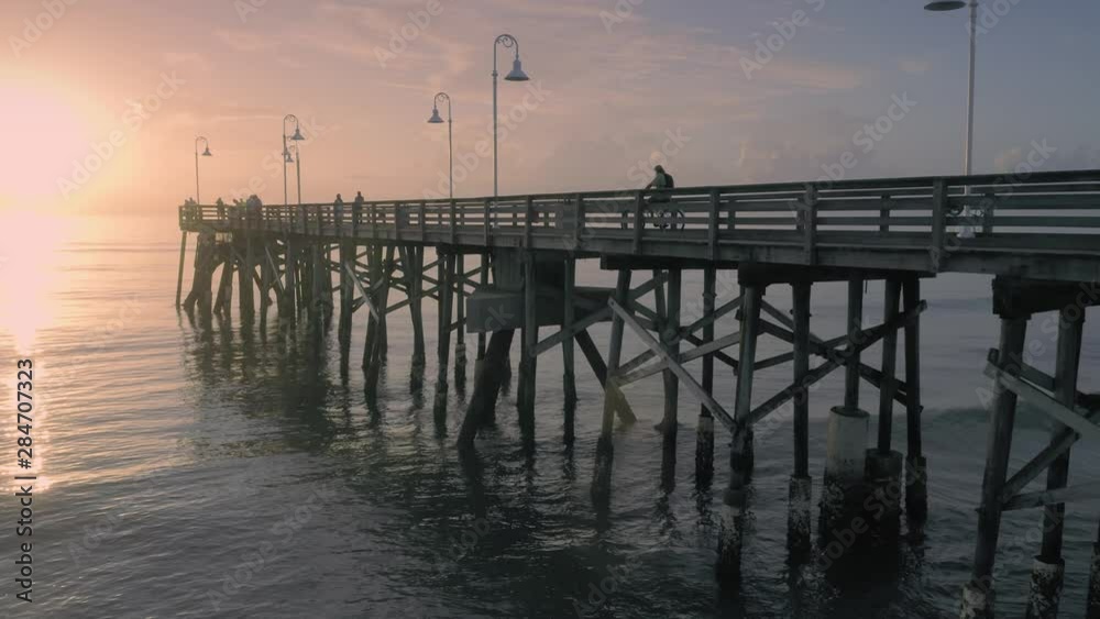 Aerial over Daytona Beach and people fishing off a pier at sunrise. Daytona, Florida, USA. 22 July 2019 Aerial over Daytona Beach and people fishing off a pier at sunrise. Daytona, Florida, USA. 22 July 2019