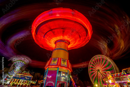 Spinning ride at the fair in the late night illuminated with lights