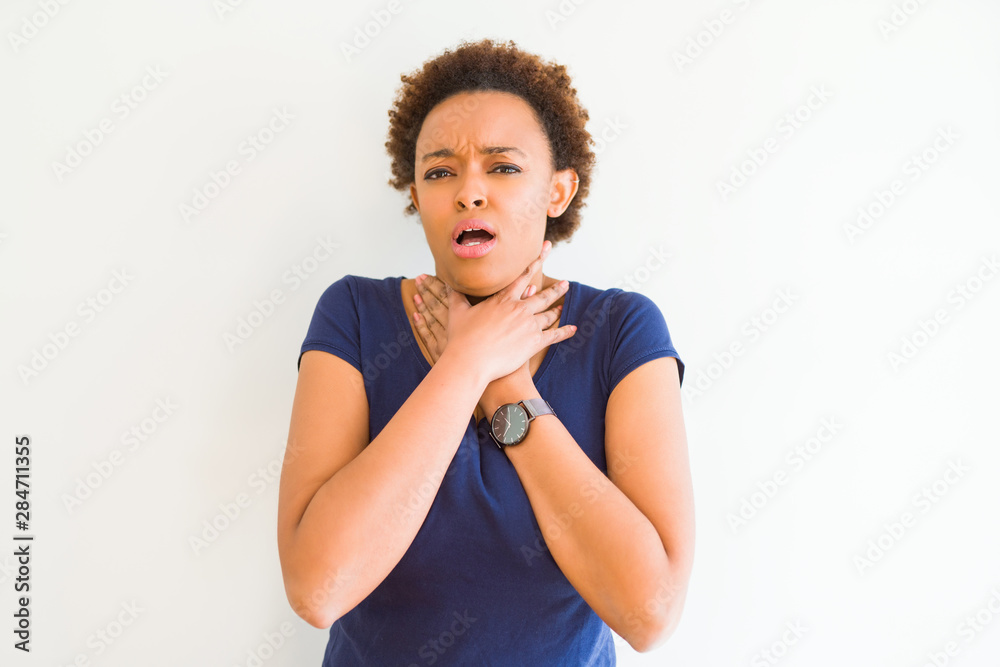 Young beautiful african american woman over white background shouting and suffocate because painful strangle. Health problem. Asphyxiate and suicide concept. Young beautiful african american woman over white background shouting and suffocate because painful strangle. Health problem. Asphyxiate and suicide concept.