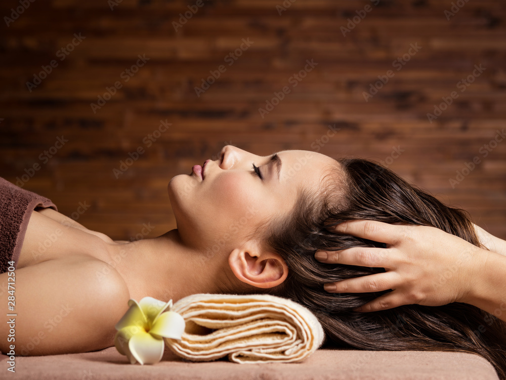 Masseur doing massage the head and hair for an woman in spa salon - obrazy, fototapety, plakaty 