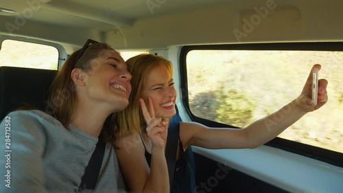 Two Gorgeous Women Taking Selfies While on a Moving Van