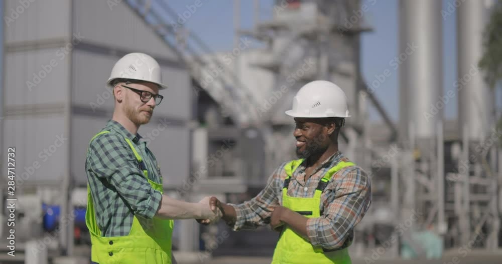 Male builders shaking hands Male builders shaking hands
