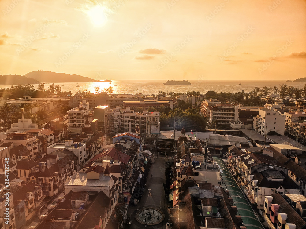 Aerial view of Patong beach, Phuket island and sea, urban city with sunset sky. Andaman sea, Thailand.