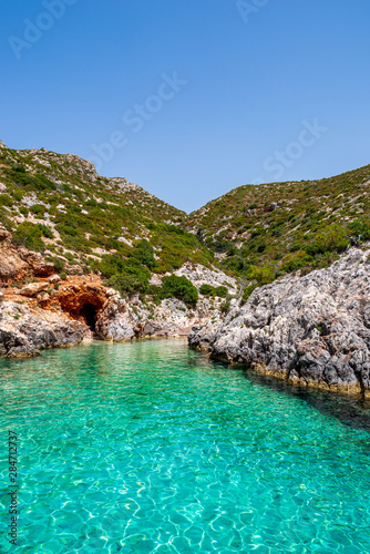 Small, paradisiacal bay of Porto Limnionas with view over the clear, turquoise water and rocks covered with bushes, Zakynthos, Greece © Frank Kuschmierz