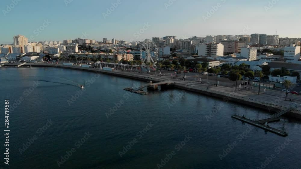 Aerial of relaxed tourist city Portimao riverside promenade with ferris wheel, Algarve, Portugal Aerial of relaxed tourist city Portimao riverside promenade with ferris wheel, Algarve, Portugal