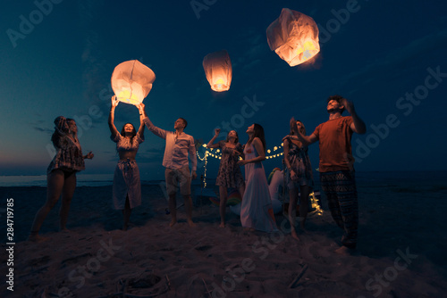 Canvas Print Group of friends lighting lanterns
