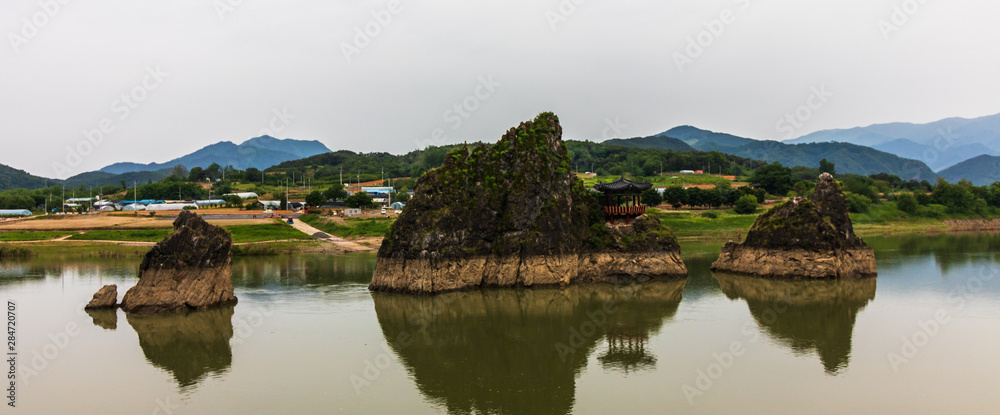 Panoramic view on Dodamsambong Peaks. Three stone peaks rising out of the Namhangang River. Danyang, North Chungcheong, South Korea, Asia. Panoramic view on Dodamsambong Peaks. Three stone peaks rising out of the Namhangang River. Danyang, North Chungcheong, South Korea, Asia.
