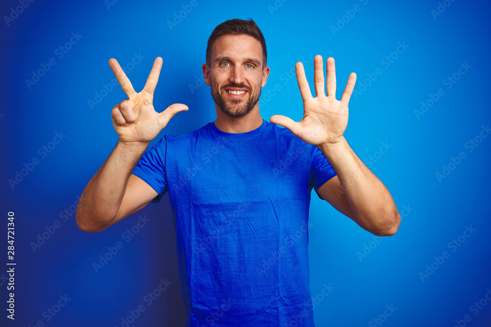 Young handsome man wearing casual t-shirt over blue isolated background showing and pointing up with fingers number eight while smiling confident and happy. Young handsome man wearing casual t-shirt over blue isolated background showing and pointing up with fingers number eight while smiling confident and happy.