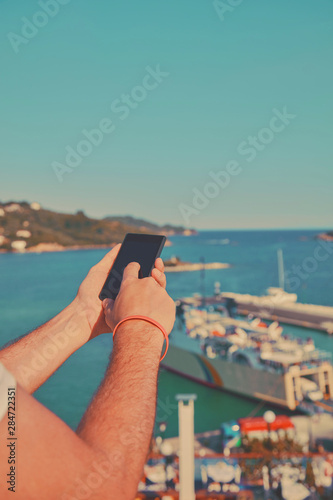 Modern man using cellphone and enjoying the view.