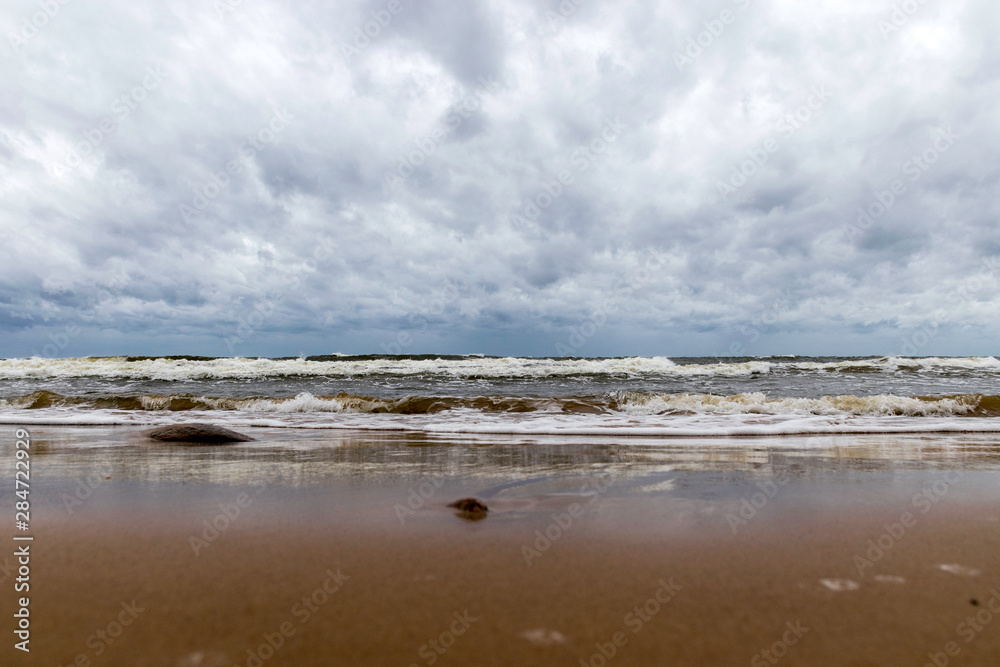 beautiful waves going to the coast, stormy sea with thunder clouds over,