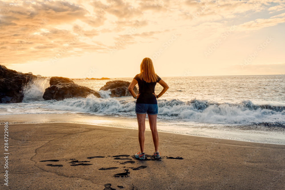 Romatic girl standing on sunset beach Tenerife