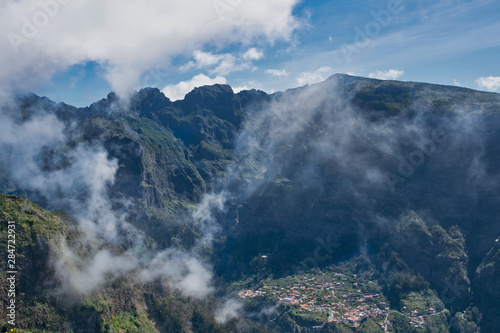 View from the hiking trail at the Boca da Corrida belvedere on the Encumeada pass on Madeira Island, Portugal in summer, View to the village of Curral das Freiras  © Gandarina Ekaterina