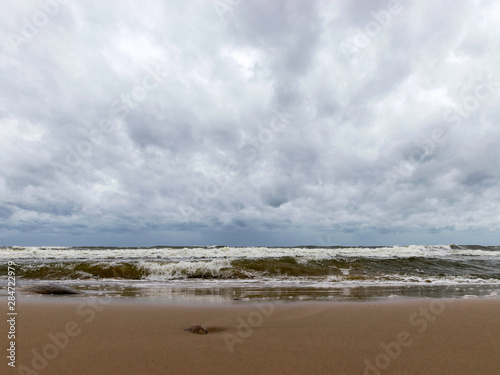 beautiful waves going to the coast  stormy sea with thunder clouds over 