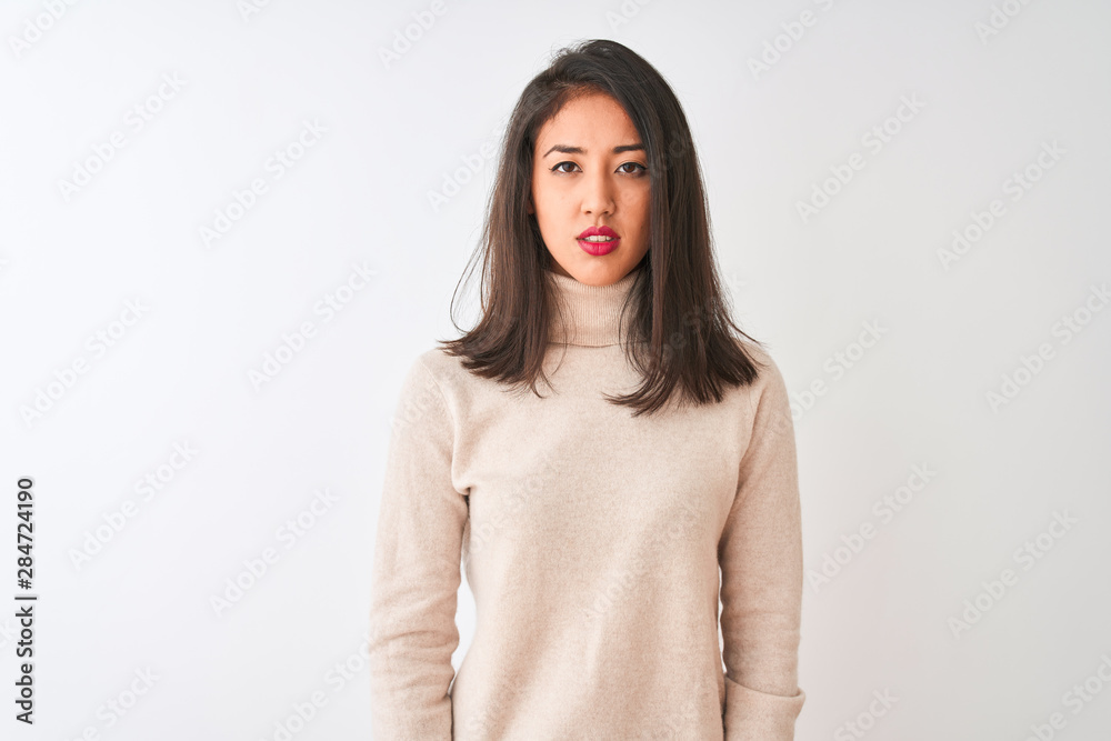 Beautiful chinese woman wearing turtleneck sweater standing over isolated white background Relaxed with serious expression on face. Simple and natural looking at the camera. Beautiful chinese woman wearing turtleneck sweater standing over isolated white background Relaxed with serious expression on face. Simple and natural looking at the camera.