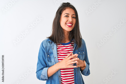 Young chinese woman wearing striped t-shirt and denim shirt over isolated white background Hands together and fingers crossed smiling relaxed and cheerful. Success and optimistic