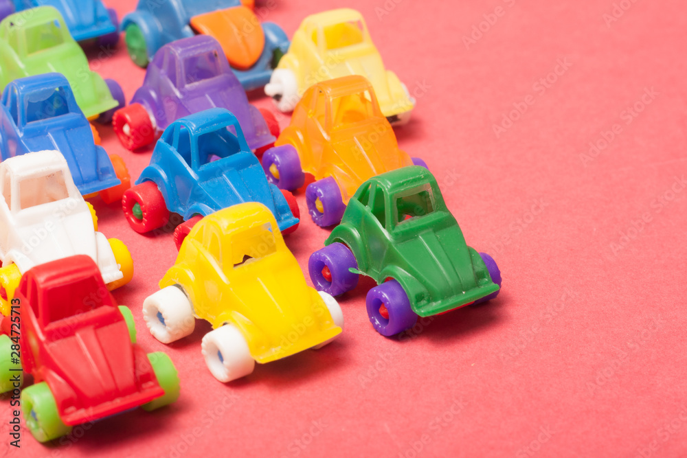 Obraz premium Toys plastic cars on a red background