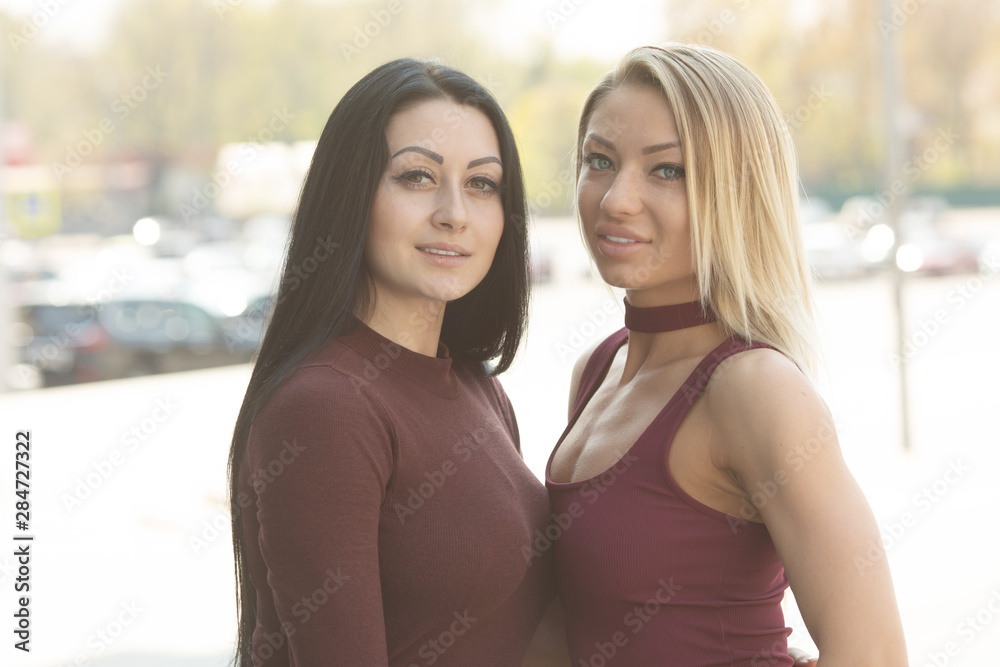 Two women friends laughing with a perfect white teeth with a green background. Two women friends laughing with a perfect white teeth with a green background.