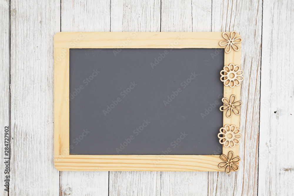 Blank chalkboard with flowers on weathered whitewash textured wood background Blank chalkboard with flowers on weathered whitewash textured wood background