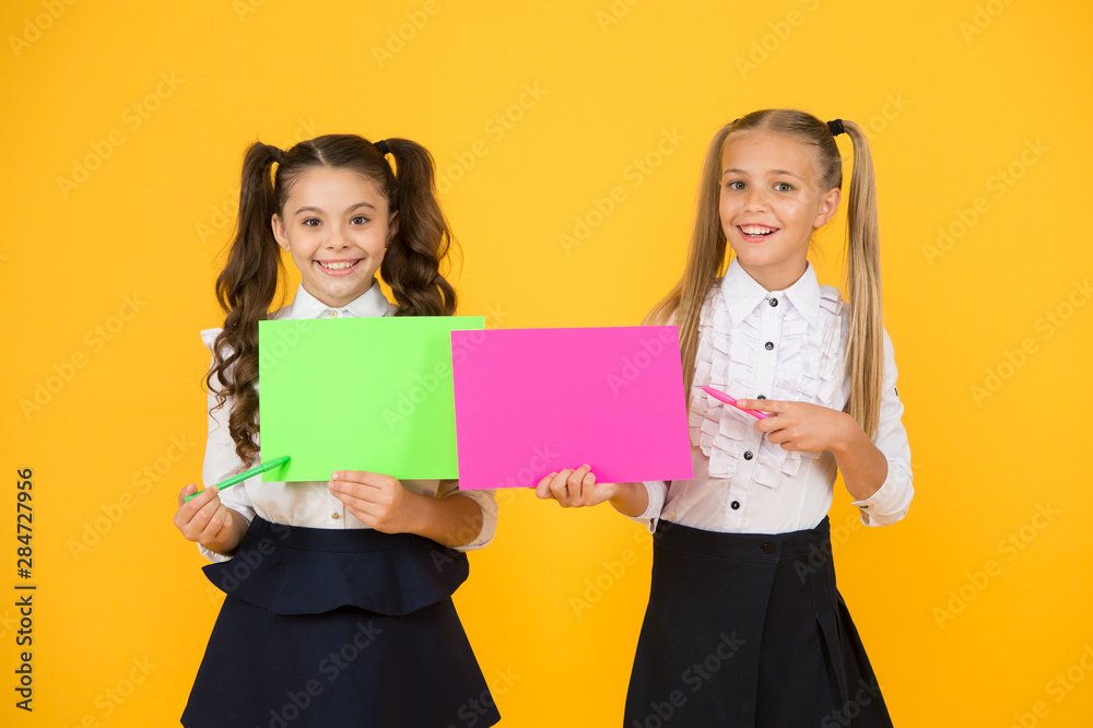 Girls school uniform hold poster. Visual communication concept. School friendship. School girls show poster. Presentation poster copy space. Children presenting own projects. Explain main point Girls school uniform hold poster. Visual communication concept. School friendship. School girls show poster. Presentation poster copy space. Children presenting own projects. Explain main point