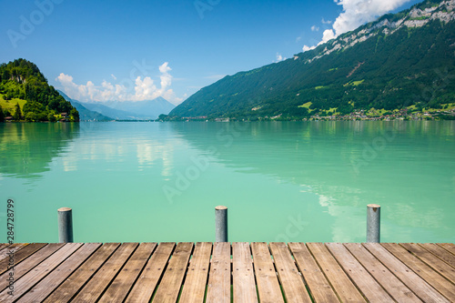 View of Brienz lake with clear turquoise water. Wooden pier. Brienz lake in the village of Iseltwald, Switzerland. © bbgreg