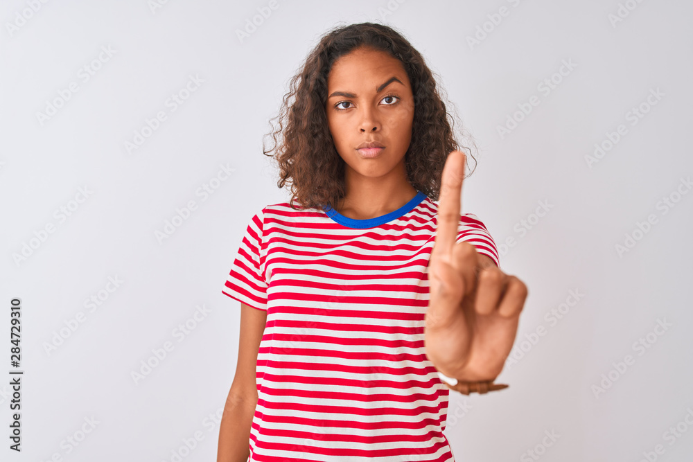 Young brazilian woman wearing red striped t-shirt standing over isolated white background Pointing with finger up and angry expression, showing no gesture Young brazilian woman wearing red striped t-shirt standing over isolated white background Pointing with finger up and angry expression, showing no gesture