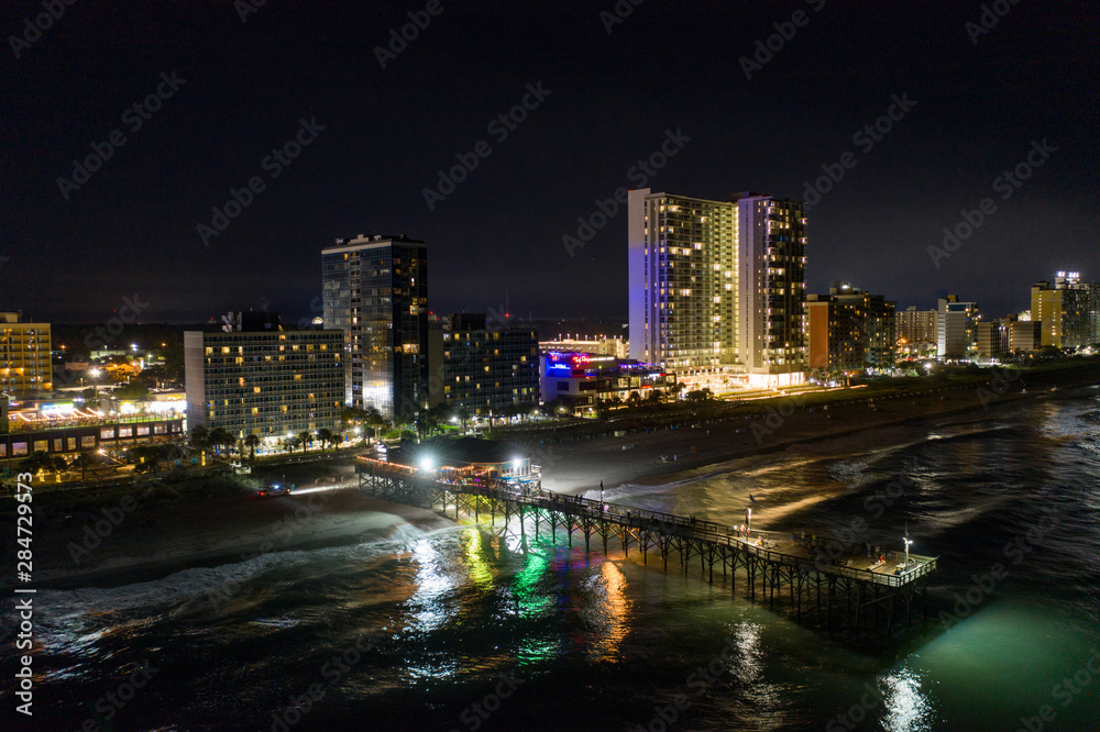 Naklejka premium Aerial night photo Myrtle Beach fishing pier and hotel condominiums