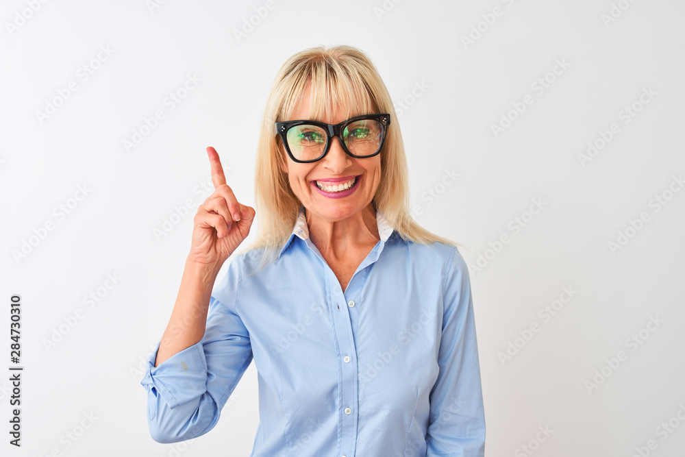 Middle age businesswoman wearing sunglasses and shirt over isolated white background surprised with an idea or question pointing finger with happy face, number one