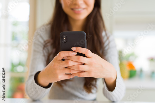 Close up of woman hands using smartphone smiling