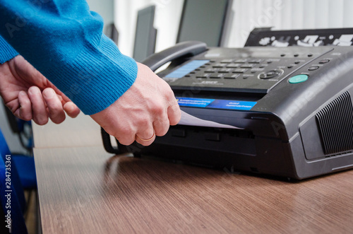 hand man are using a fax machine in the office Business concept photo