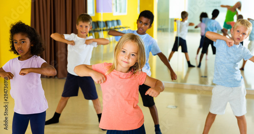 Portrait of smiling children practicing sport dance in modern dance hall