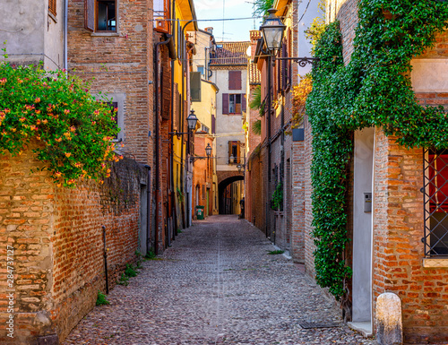 Fototapeta Naklejka Na Ścianę i Meble -  Cozy narrow street in Ferrara, Emilia-Romagna, Italy. Ferrara is capital of the Province of Ferrara