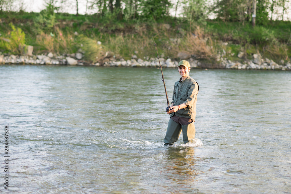 Man holding a fishing pole in a river Man holding a fishing pole in a river