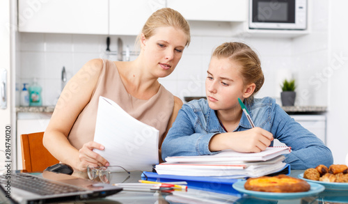 Mother helping daughter with home task