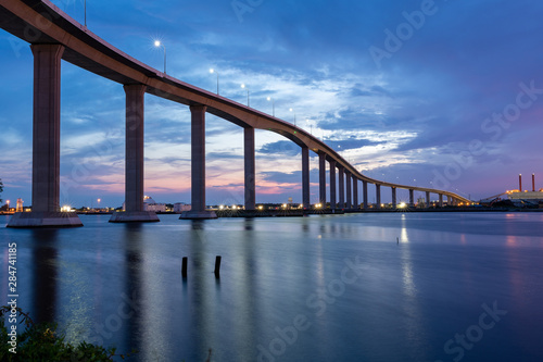 The Jordan Bridge over the Elizabeth River on the border of Norfolk and Chesapeake Virginia against a beautiful red, purple, pink, and blue sunset photo