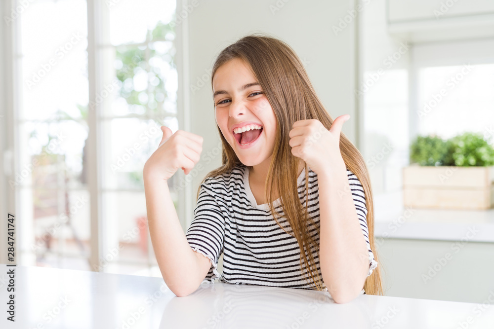 Beautiful young girl kid wearing stripes t-shirt success sign doing positive gesture with hand, thumbs up smiling and happy. Looking at the camera with cheerful expression, winner gesture. Beautiful young girl kid wearing stripes t-shirt success sign doing positive gesture with hand, thumbs up smiling and happy. Looking at the camera with cheerful expression, winner gesture.